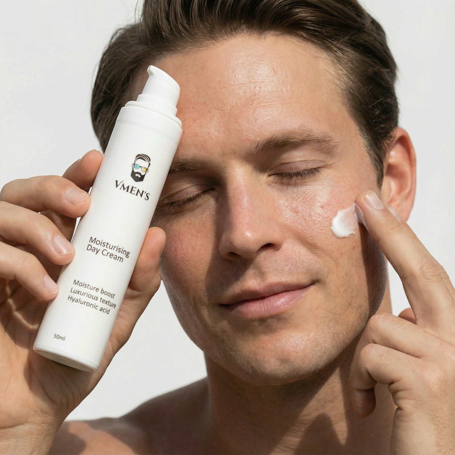Man applying moisturizing cream to his face with a bottle labeled &