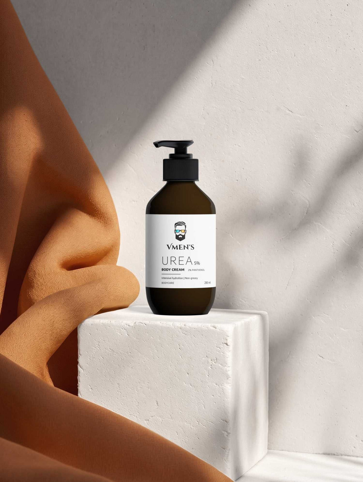 VMEN’S 5% Hydroxyethyl Urea + 2% Panthenol Body Cream beside terracotta fabric on a white stone block.