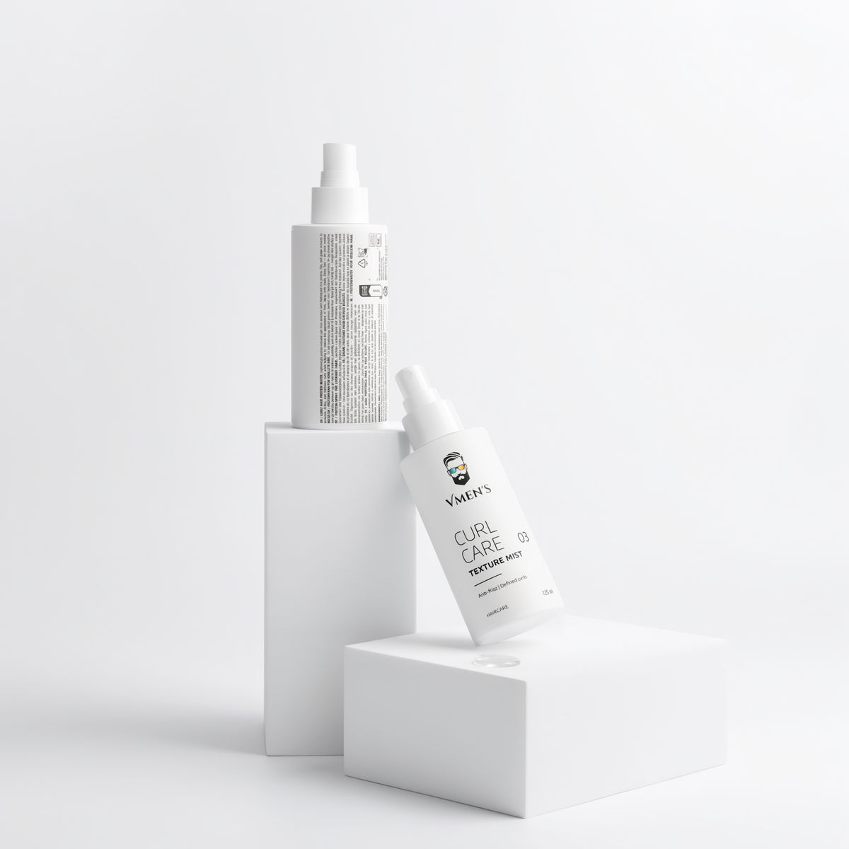 Front and back views of VMEN’S Anti-Frizz Curly Hair Texture Mist for Men bottles on white display blocks.