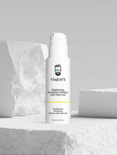 VMEN’S Kojic Acid Face & Body Exfoliator displayed among white stone blocks.