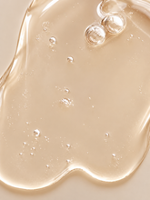 Close-up of VMEN’S Sensitive Scalp Shampoo for Men, showing a translucent golden gel texture with air bubbles.