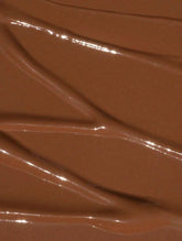Creamy brown concealer in shade 35 Deep Neutral, with a smooth, reflective finish and soft texture for blending.