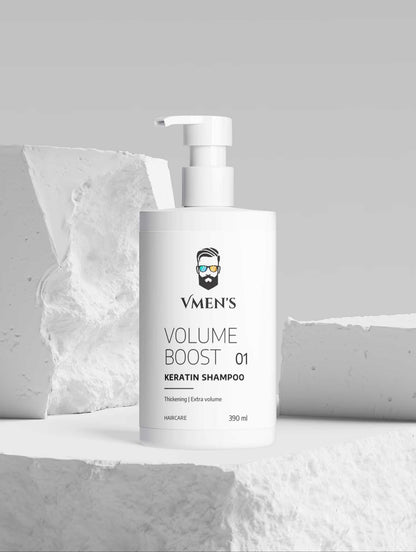 VMEN’S Keratin Volume Boost Shampoo white pump bottle displayed among white stone blocks.