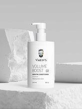 VMEN’S Keratin Volume Boost Conditioner white pump bottle displayed among white stone blocks.