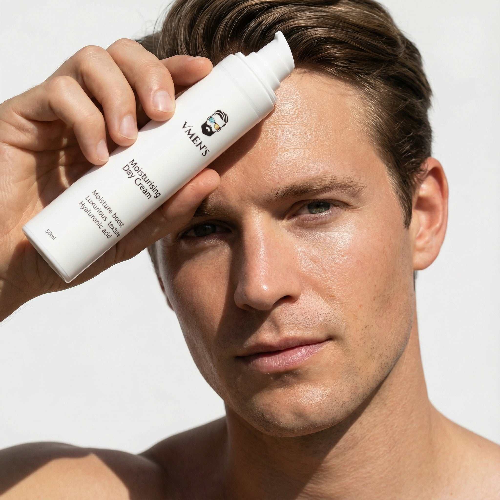 Man applying moisturizing day cream to his face with a white background