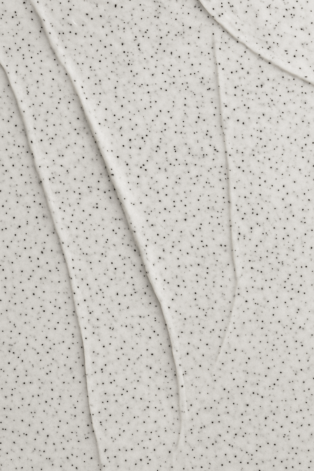 Close-up of the vmen's  scrub's creamy texture with visible volcanic sand particles.