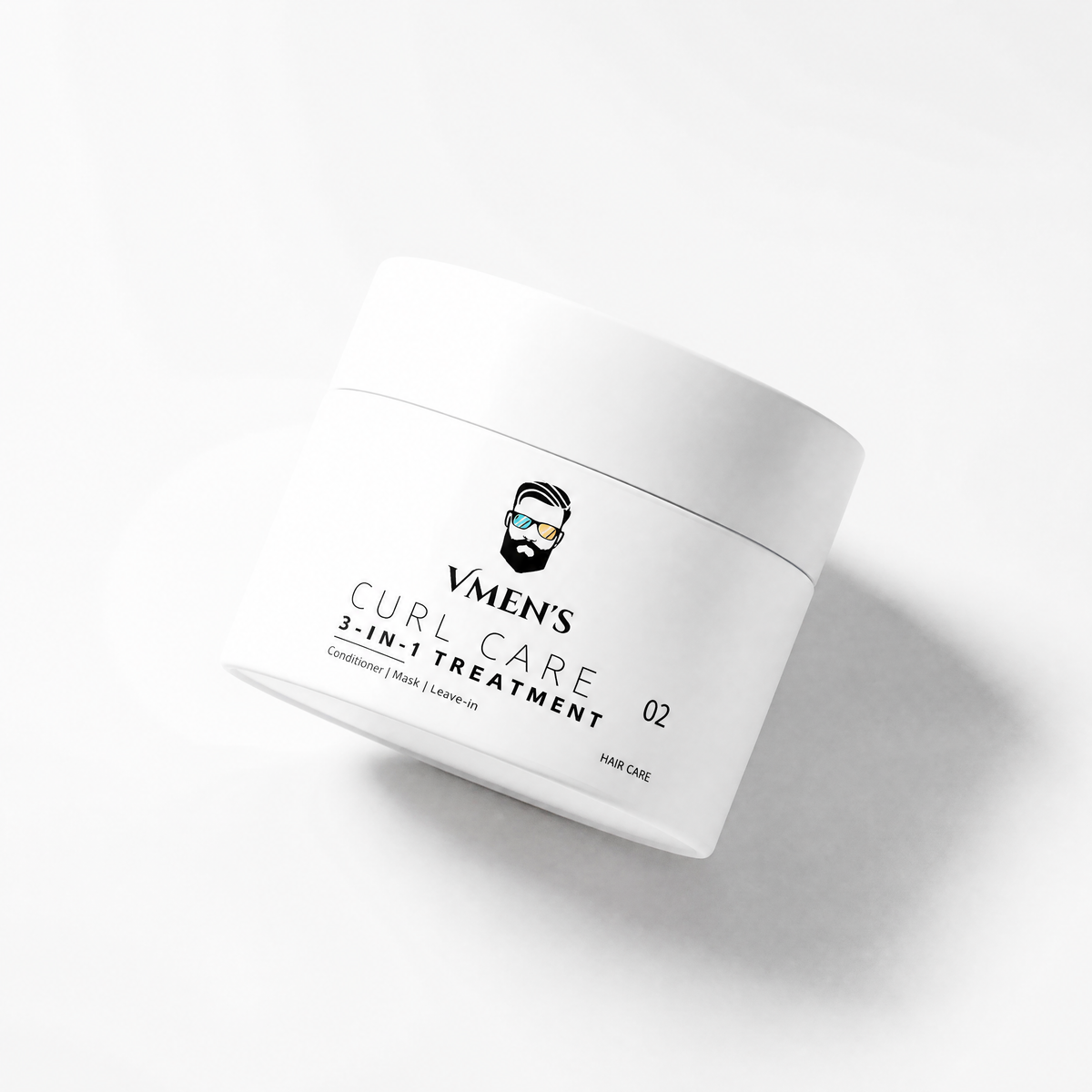 VMEN’S 3-in-1 Curly Hair Treatment for Men jar tilted on a white surface with a soft shadow.